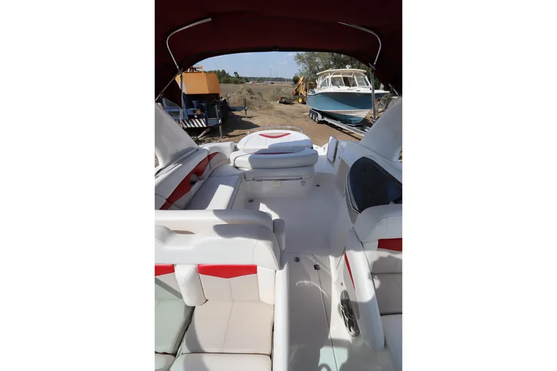 Slide: The Image of 2016 Chaparral 287 SSX boat interior with white and red seating, outdoor setting. - 11