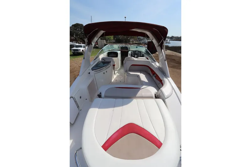 Slide: The Image of 2016 Chaparral 287 SSX boat interior with white and red seating, docked by the water. - 14