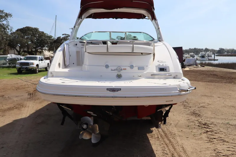 Slide: The Image of 2016 Chaparral 287 SSX boat on sandy shore, rear view with propellers visible. - 2