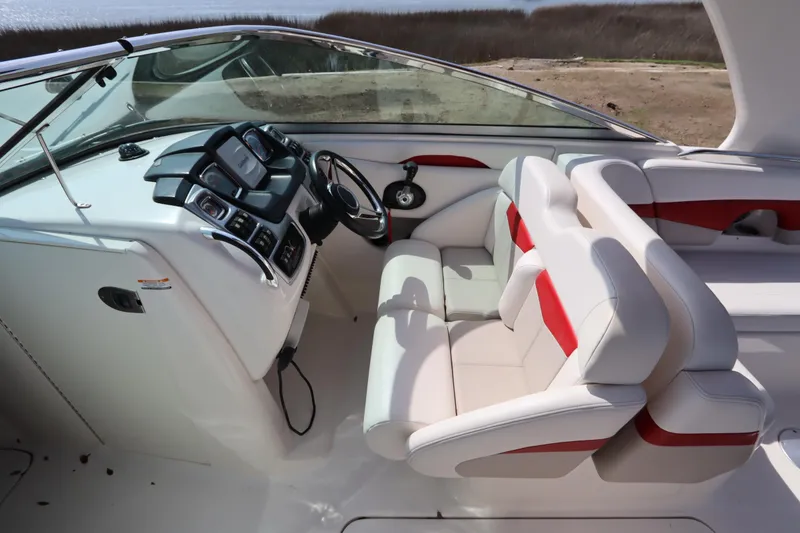 Slide: The Image of 2016 Chaparral 287 SSX boat interior with white and red seating, modern dashboard. - 23