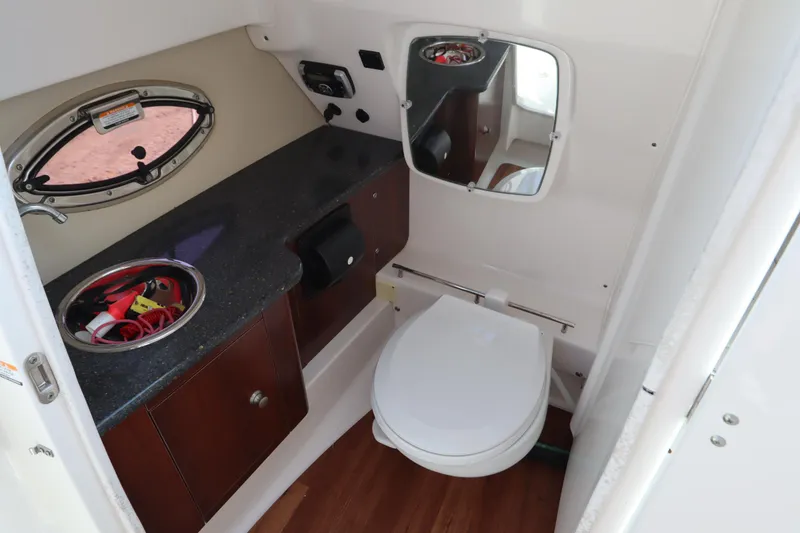 Slide: The Image of 2016 Chaparral 287 SSX boat bathroom with sink, mirror, and toilet. - 26