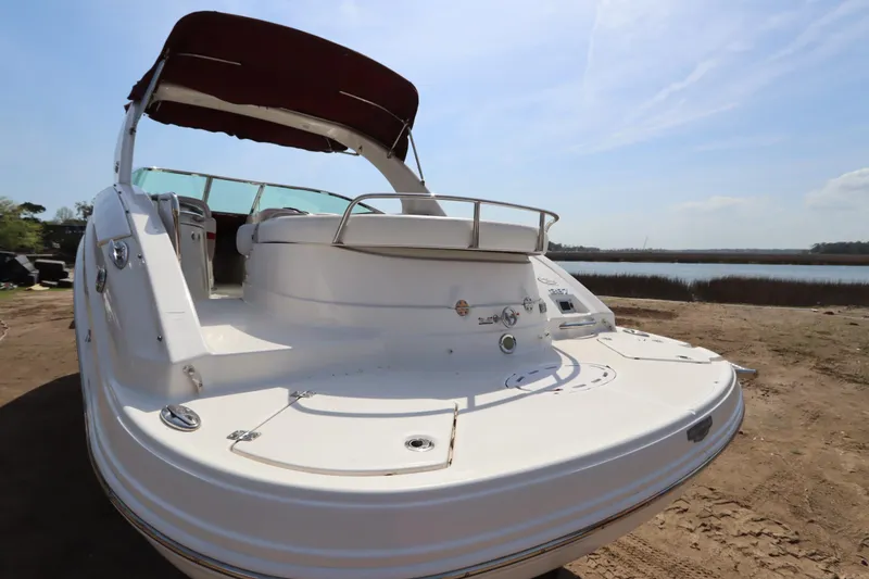 Slide: The Image of 2016 Chaparral 287 SSX boat with maroon canopy, docked by a serene lake. - 8