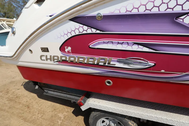 Slide: The Image of 2016 Chaparral 287 SSX boat with vibrant red and purple graphics on the side. - 9
