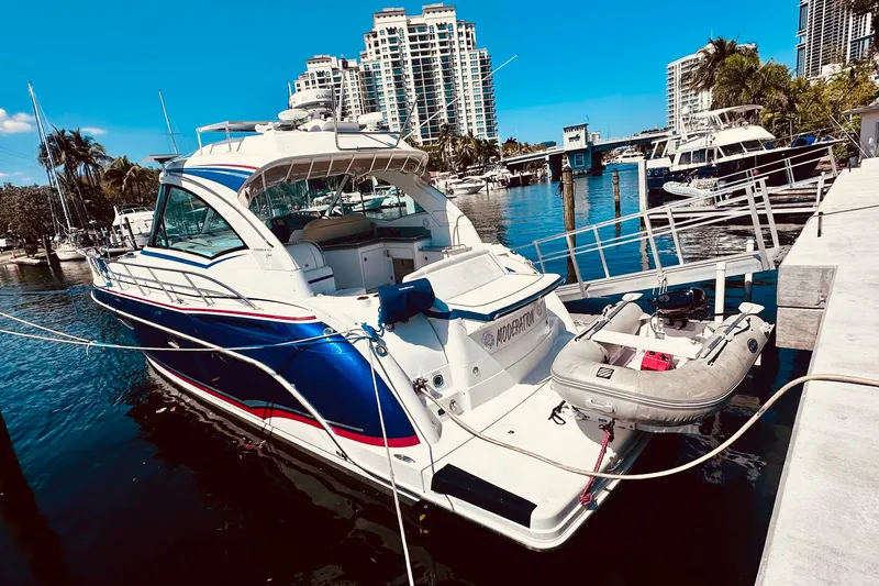 Slide: The Image of 2012 Formula 45 Yacht docked at marina with inflatable boat, cityscape background. - 4