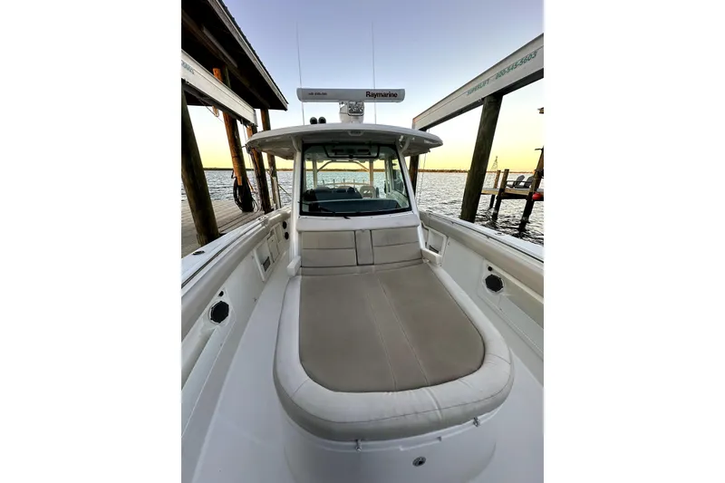 Slide: The Image of 2018 Boston Whaler 380 Outrage boat docked at sunset, featuring spacious seating. - 10