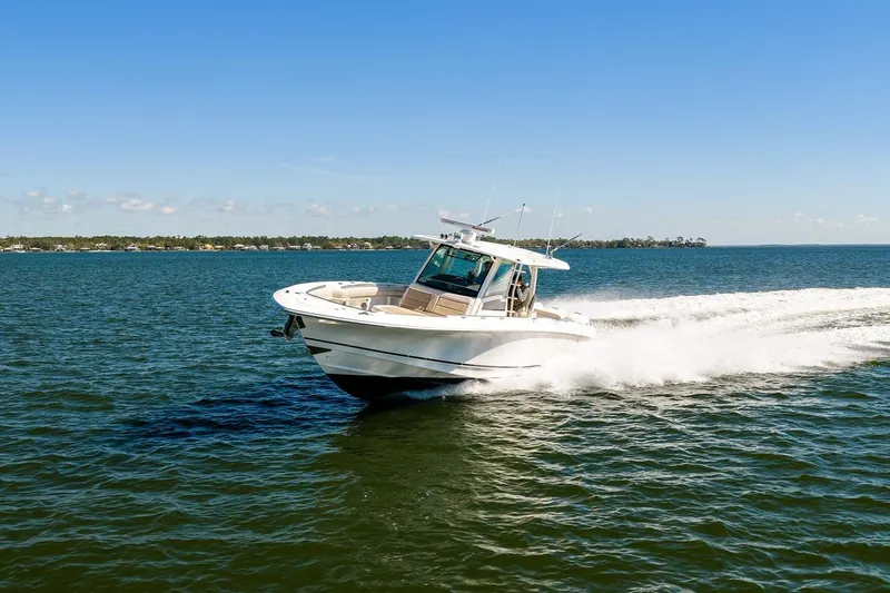 Slide: The Image of 2018 Boston Whaler 380 Outrage cruising on open water under clear blue skies. - 12