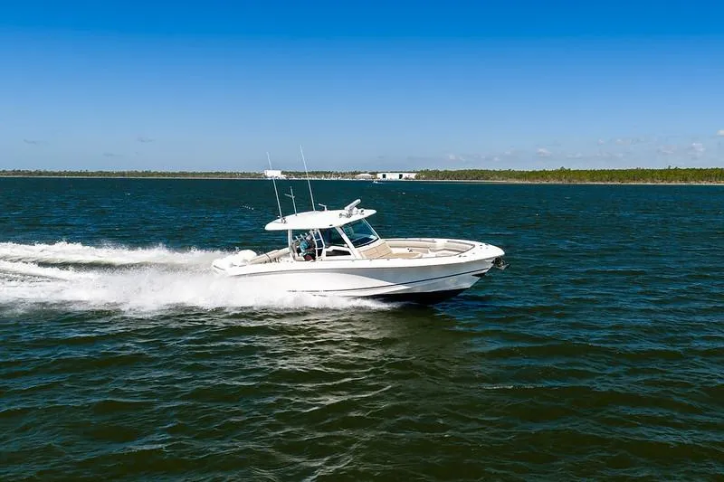 Slide: The Image of 2018 Boston Whaler 380 Outrage cruising on open water under clear blue skies. - 18