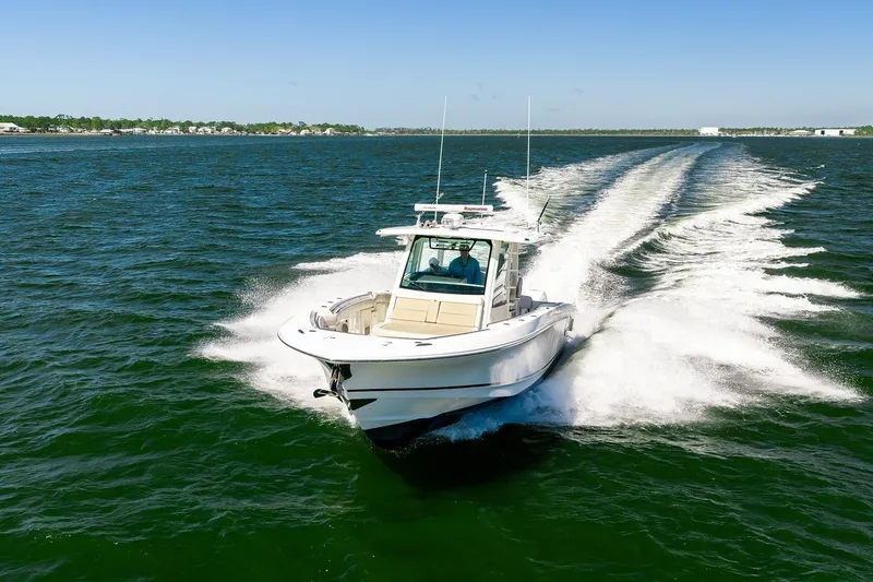 Slide: The Image of 2018 Boston Whaler 380 Outrage cruising on open water, creating a dynamic wake. - 23