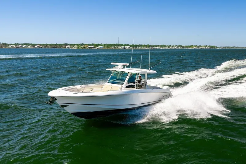 Slide: The Image of 2018 Boston Whaler 380 Outrage cruising on open water under clear blue skies. - 24