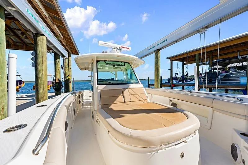 Slide: The Image of 2018 Boston Whaler 380 Outrage boat docked, featuring spacious seating and clear blue skies. - 26