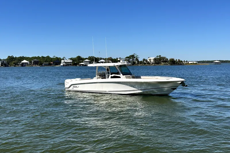 Slide: The Image of 2018 Boston Whaler 380 Outrage boat on calm water under clear blue sky. - 3