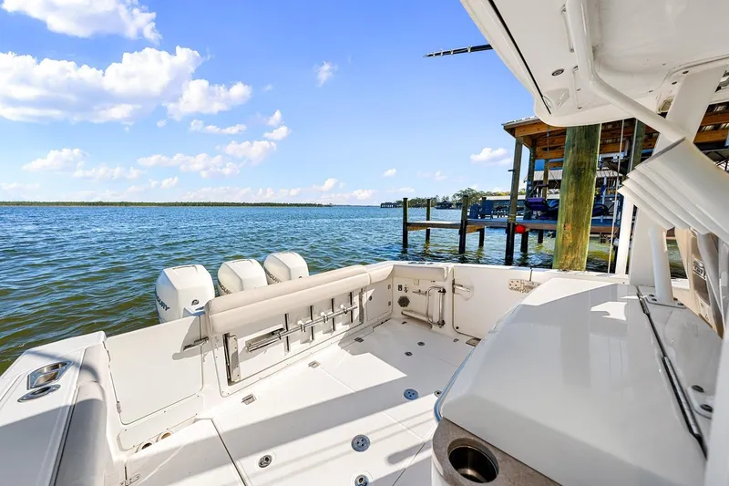 Slide: The Image of 2018 Boston Whaler 380 Outrage boat docked by serene waters under a clear blue sky. - 43