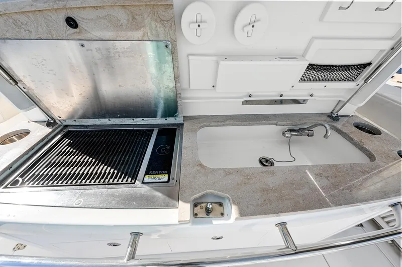 Slide: The Image of Outdoor kitchen area on a 2018 Boston Whaler 380 Outrage, featuring a grill and sink. - 44
