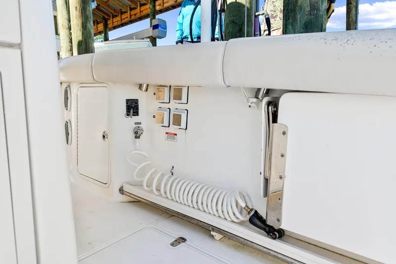 Slide: The Image of 2018 Boston Whaler 380 Outrage boat interior with coiled hose and control panel. - 48