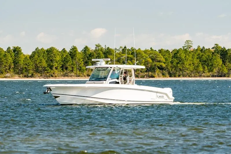 Slide: The Image of 2018 Boston Whaler 380 Outrage cruising on a scenic lake with forested shoreline. - 53