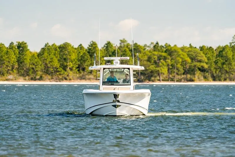 Slide: The Image of 2018 Boston Whaler 380 Outrage cruising on a scenic lake with forested shoreline. - 54