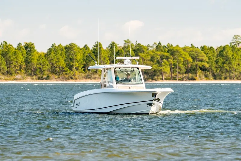 Slide: The Image of 2018 Boston Whaler 380 Outrage cruising on a scenic lake with forested shoreline. - 55