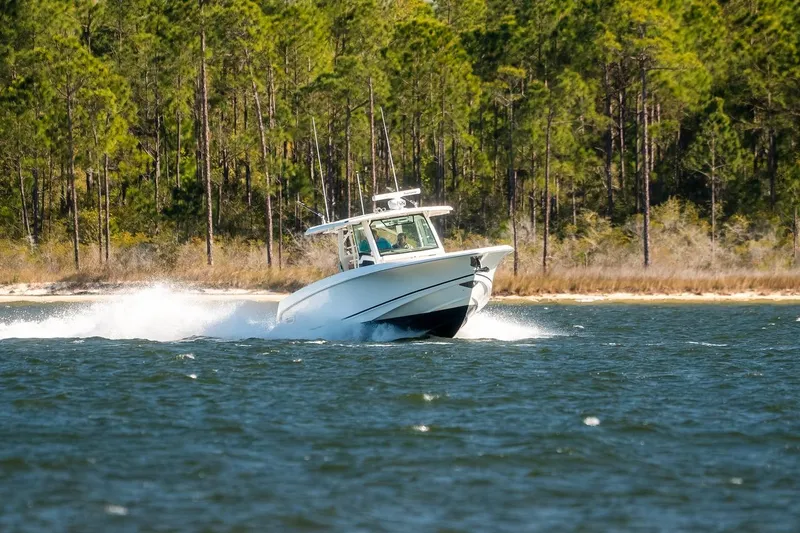 Slide: The Image of 2018 Boston Whaler 380 Outrage cruising on a scenic lake with forested shoreline. - 69