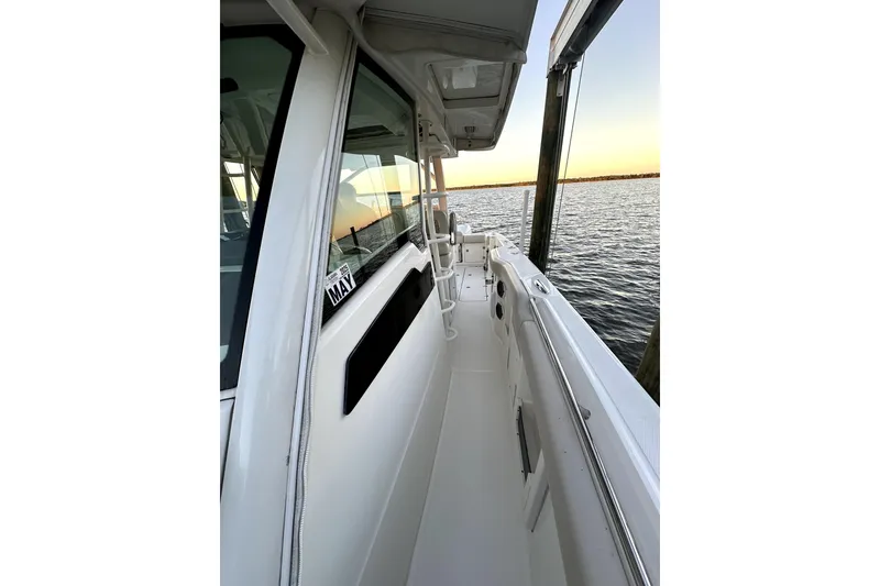 Slide: The Image of 2018 Boston Whaler 380 Outrage boat docked by the water at sunset. - 7