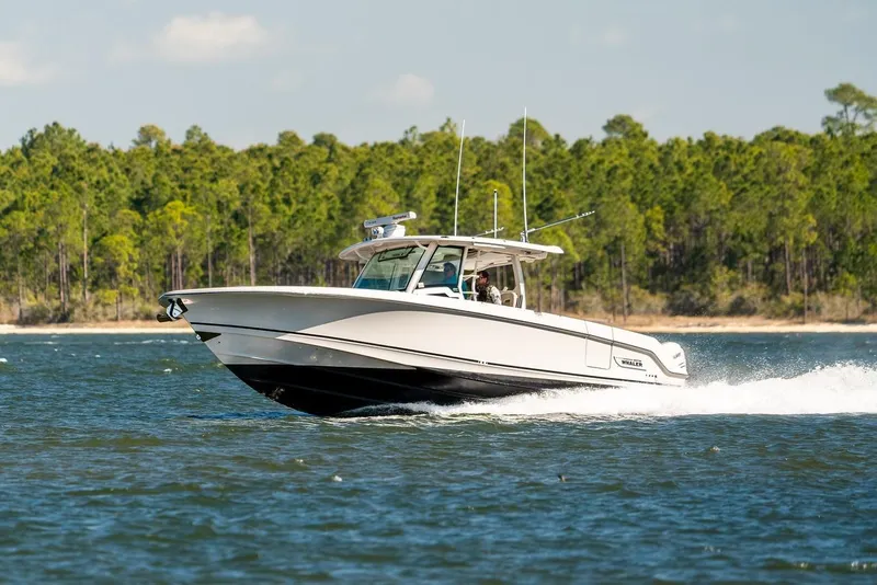 Slide: The Image of 2018 Boston Whaler 380 Outrage cruising on a scenic lake with forested shoreline. - 73