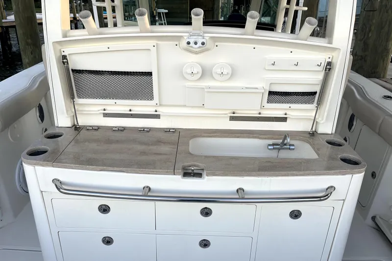 Slide: The Image of 2018 Boston Whaler 380 Outrage boat interior with sink and storage compartments. - 8
