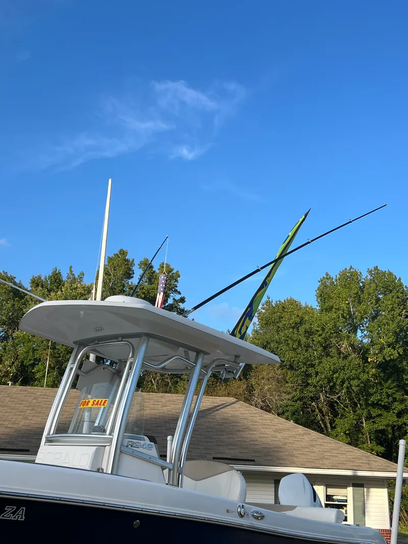 Slide: The Image of A 2020 Robalo R242 Center Console boat with fishing rod holders on the roof. - 17