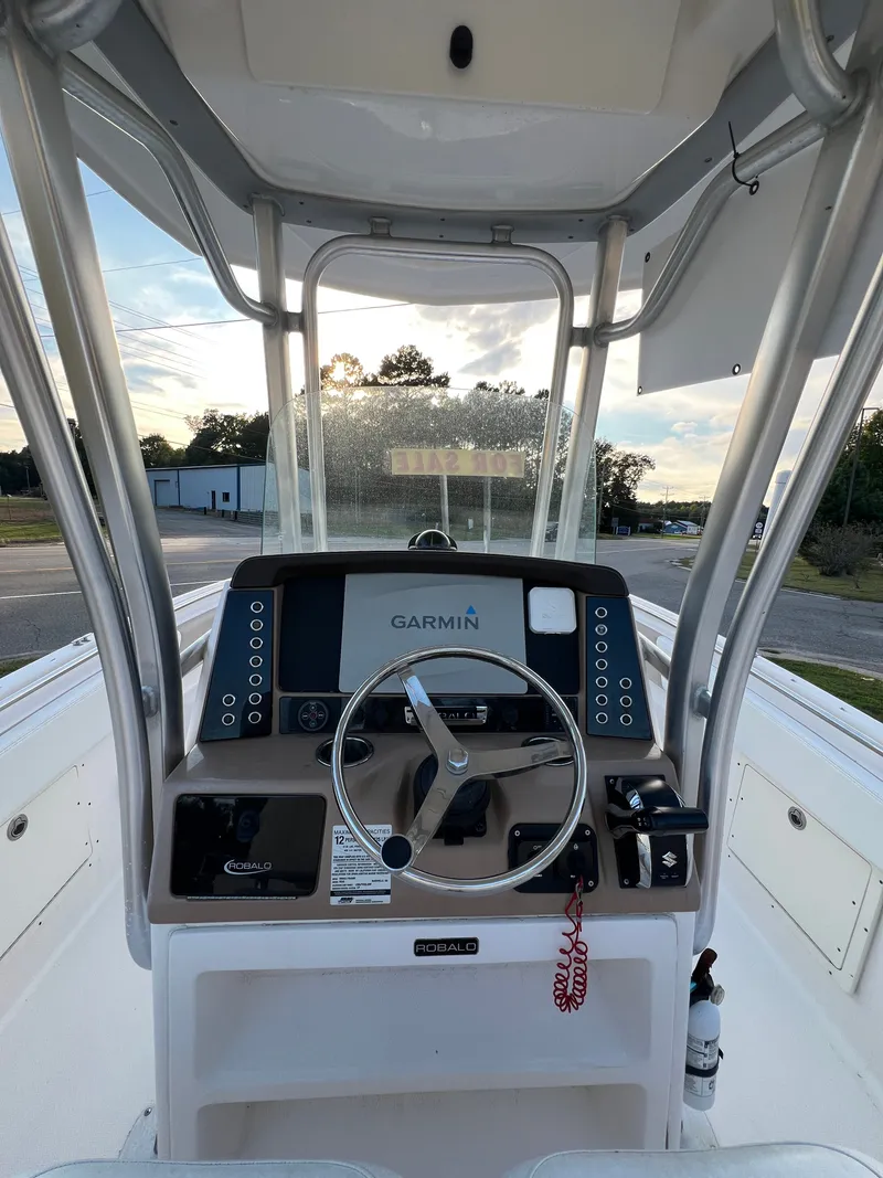 Slide: The Image of The image shows the helm of a 2020 Robalo R242 Center Console boat with Garmin navigation. - 32