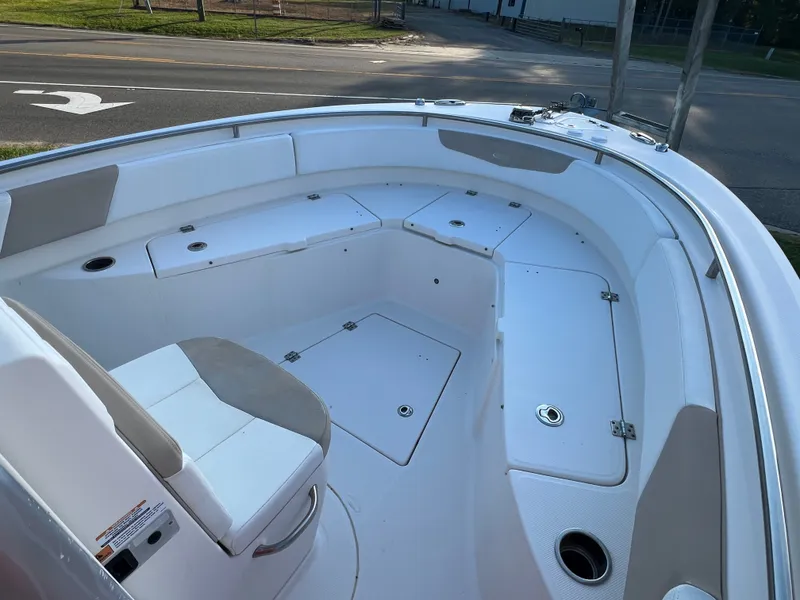 Slide: The Image of The image shows the bow of a 2020 Robalo R242 Center Console boat with seating and storage. - 23