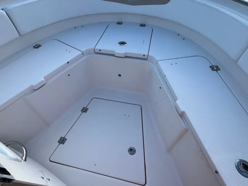 Slide: The Image of The image shows the bow area of a 2020 Robalo R242 Center Console boat with storage compartments. - 24