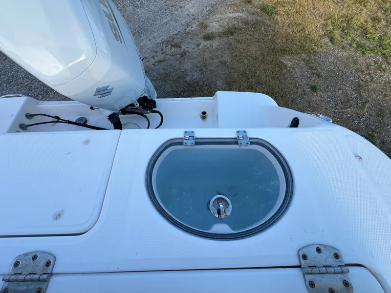 Slide: The Image of The image shows the stern of a Robalo R242 Center Console boat with a Suzuki outboard motor and a round livewell. - 29