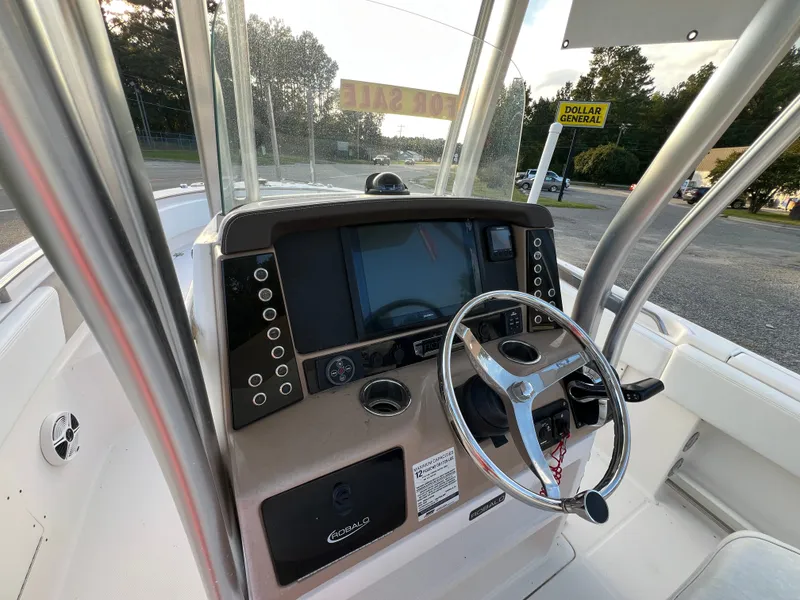 Slide: The Image of The image shows the helm of a 2020 Robalo R242 Center Console boat. - 33