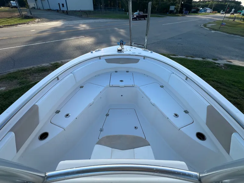 Slide: The Image of The image shows the bow of a 2020 Robalo R242 Center Console boat with seating and storage. - 22