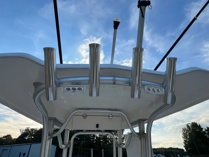 Slide: The Image of The image shows the T-top structure of a Robalo R242 Center Console boat with fishing rod holders. - 18