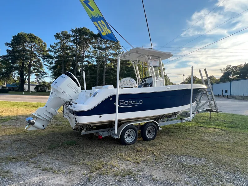 Slide: The Image of A 2020 Robalo R242 Center Console boat on a trailer in a grassy area. - 14