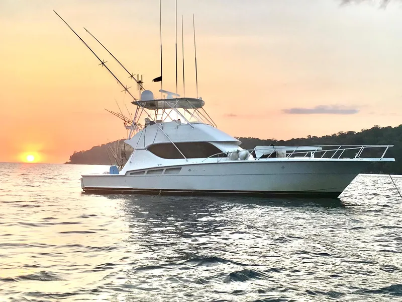Slide: The Image of 2001 Hatteras 50 Convertible yacht at sunset on the water. - 1