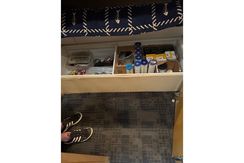 Slide: The Image of Storage compartment on a 2001 Hatteras 50 Convertible boat with various supplies. - 41