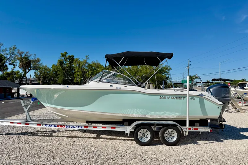 The Image of 2023 Key West 239 DFS boat on trailer, parked outdoors under clear blue sky. - 0