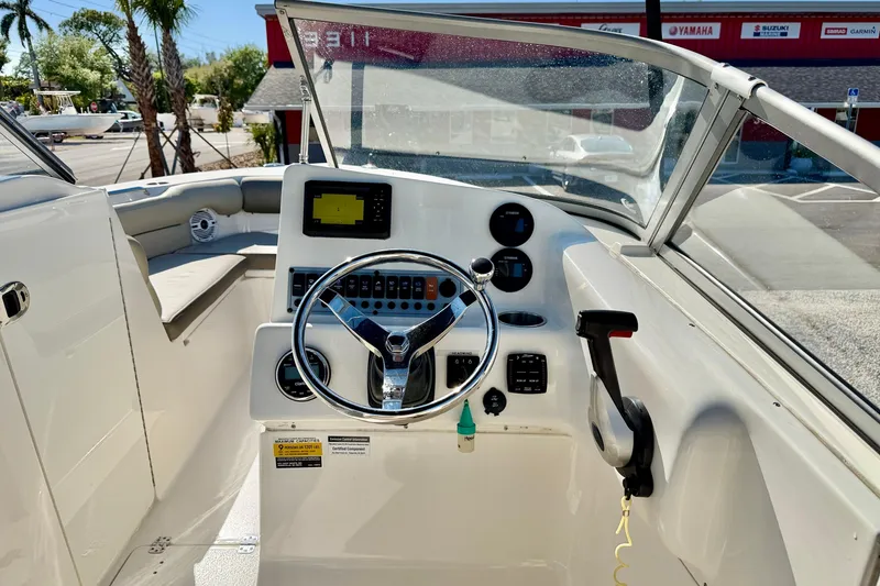 Slide: The Image of 2023 Key West 239 DFS boat dashboard with steering wheel and controls. - 14