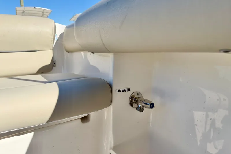 Slide: The Image of 2023 Key West 239 DFS boat interior with raw water outlet and beige seating. - 25