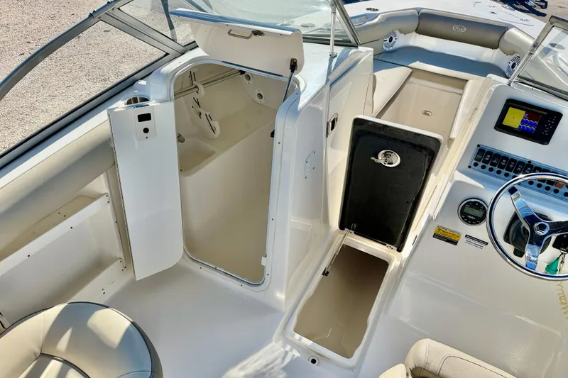 Slide: The Image of 2023 Key West 239 DFS boat interior with open storage compartments and steering console. - 26