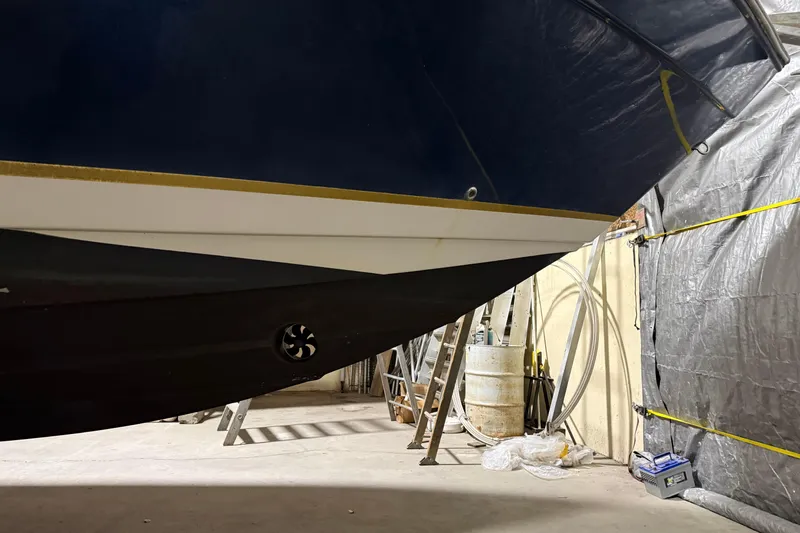 Slide: The Image of 2003 Rinker 342 Express Cruiser in a workshop, showing hull details and maintenance equipment. - 7