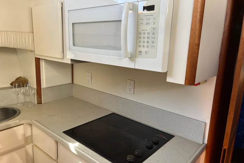 Slide: The Image of Compact kitchen area in a 1990 Californian 52 Cockpit Motor Yacht with microwave and stovetop. - 10