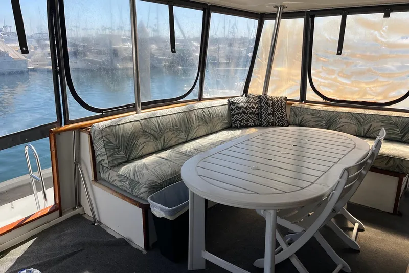 Slide: The Image of Interior of 1990 Californian 52 Cockpit Motor Yacht with cushioned seating and table. - 12