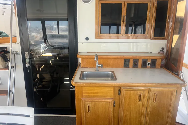 Slide: The Image of 1990 Californian 52 Cockpit Motor Yacht interior with wooden cabinetry and sink. - 13