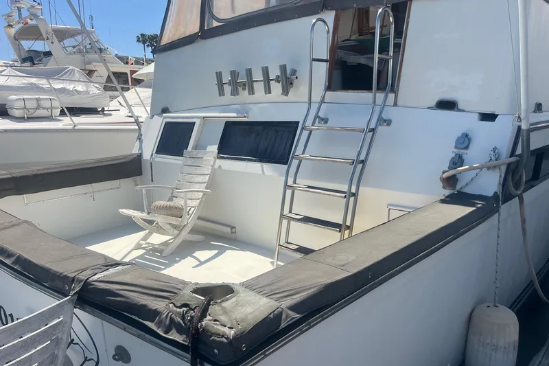 Slide: The Image of 1990 Californian 52 Cockpit Motor Yacht with ladder and seating area at marina. - 14