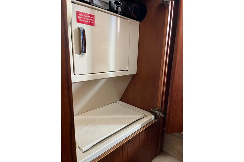 Slide: The Image of Laundry area inside 1990 Californian 52 Cockpit Motor Yacht with dryer and ventilation instructions. - 21