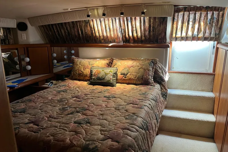 Slide: The Image of Cozy bedroom in 1990 Californian 52 Cockpit Motor Yacht with floral bedding and natural light. - 3