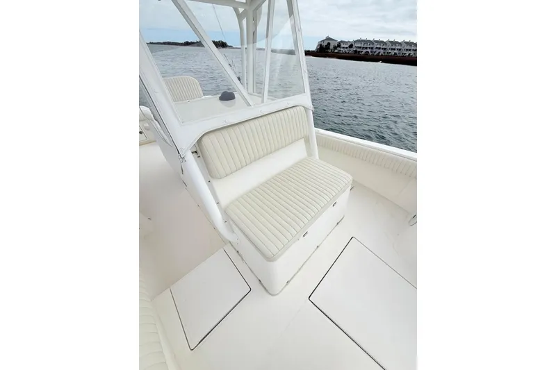 Slide: The Image of 2003 Regulator 26 Forward Seating boat interior with cushioned seats by the water. - 18