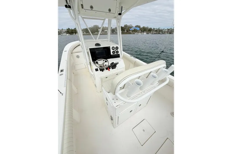 Slide: The Image of 2003 Regulator 26 Forward Seating boat interior with helm, rod holders, and water view. - 20