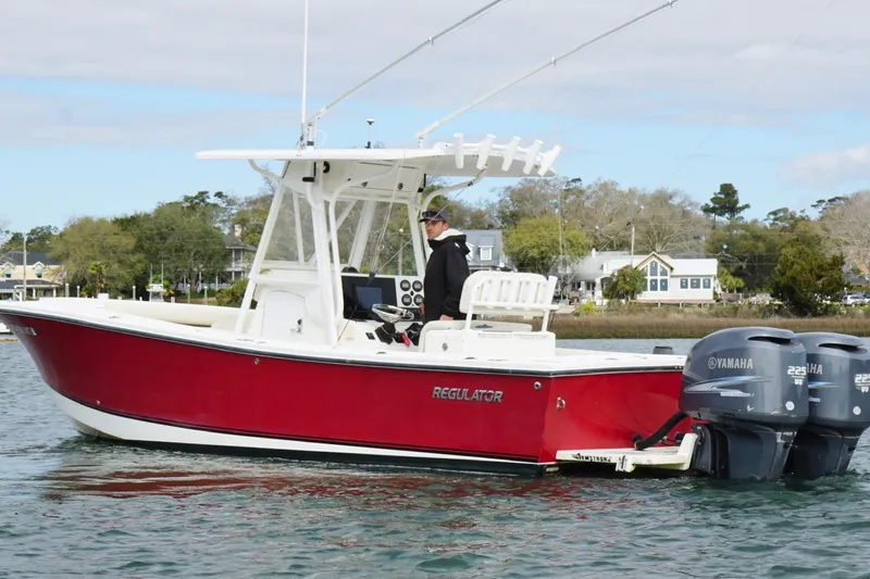 Slide: The Image of 2003 Regulator 26 Forward Seating boat with dual Yamaha engines on calm water. - 3